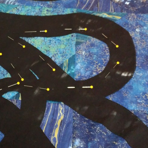 Pinning to assist with keeping fusible down for machine applique